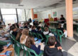 Une salle de classe de l'Aéroclub de l'Aisne remplie de jeunes élèves attentifs suivant une présentation du BIA animée par une instructrice debout devant un écran de projection