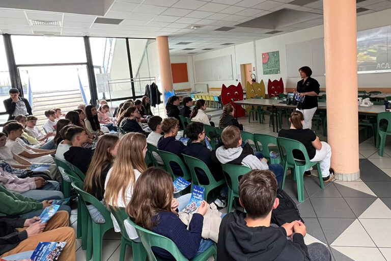 Une salle de classe de l'Aéroclub de l'Aisne remplie de jeunes élèves attentifs suivant une présentation du BIA animée par une instructrice debout devant un écran de projection